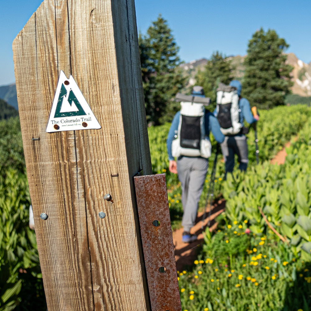 Hikers wearing the CS40 Ultra Backpack after hiking past a Colorado Trail sign post