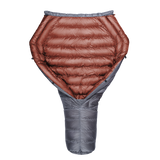 Top-down view of a backpacking quilt partially open, showing its red insulated interior and gray tapered footbox.
