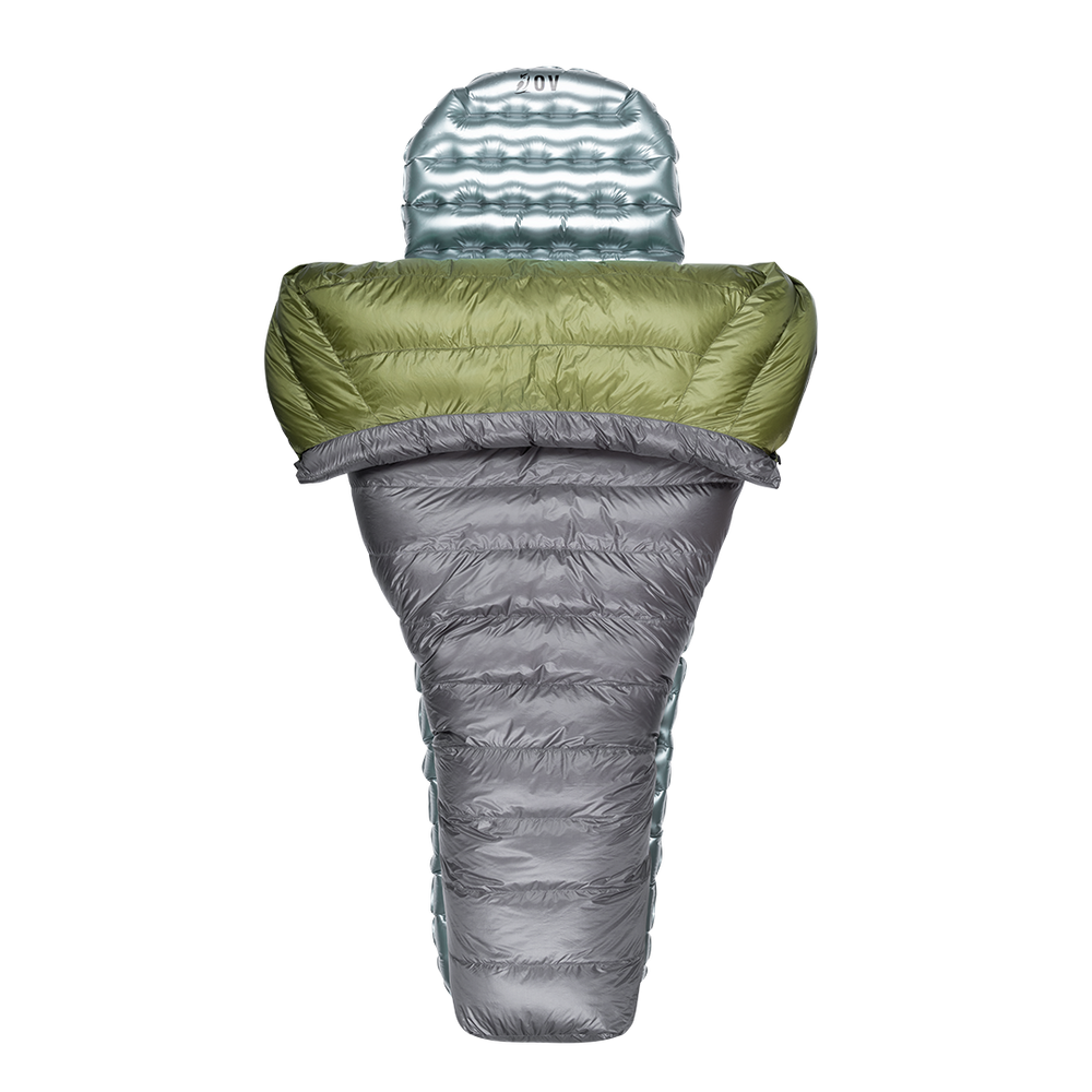 Top-down view of a gray and green backpacking quilt partially open, shown with a silvery inflatable sleeping pad inside.