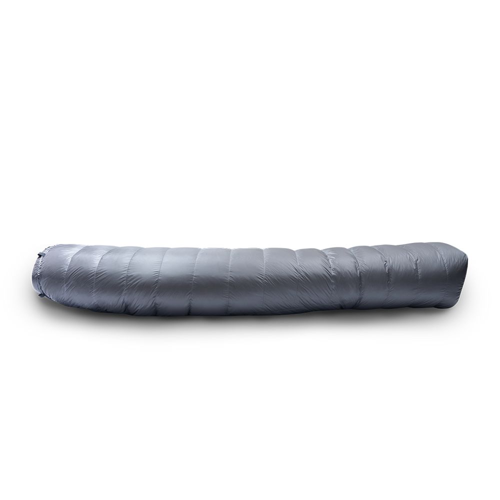 Side profile view of a gray backpacking quilt fully closed, showing its insulated baffles and tapered shape.