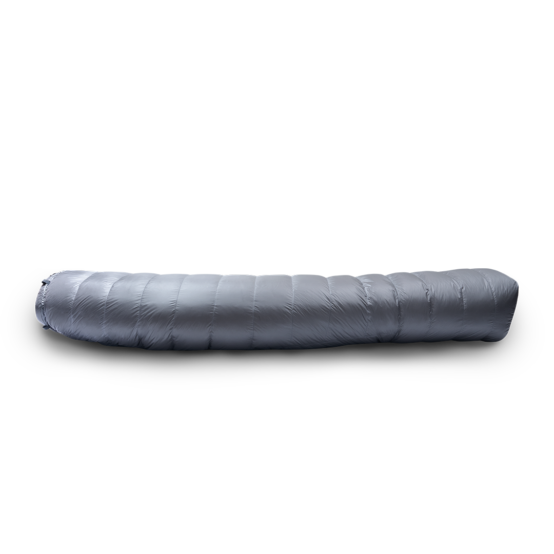 Side profile view of a gray backpacking quilt fully closed, showing its insulated baffles and tapered shape.
