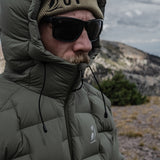 Man wearing sunglasses and beanie with the Outdoor Vitals Vantage Alpine Down Jacket hood cinched for warmth.