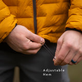 Hands adjusting drawcord hem on insulated down jacket to seal in warmth.
