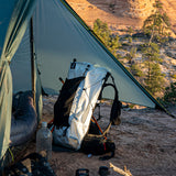 CS40 Ultra Backpack on the ground beneath tent vestibule as morning sunlight shines from the right
