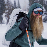 side view of man with long beard wearing ultralight backpack in snowy conditions