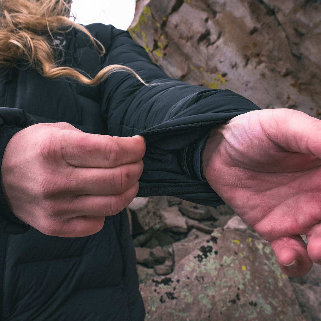 close view of elasticized cuff on black puffy jacket in high mountain environment.