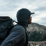 side view of man wearing fleece hoodie looking off mountain peak