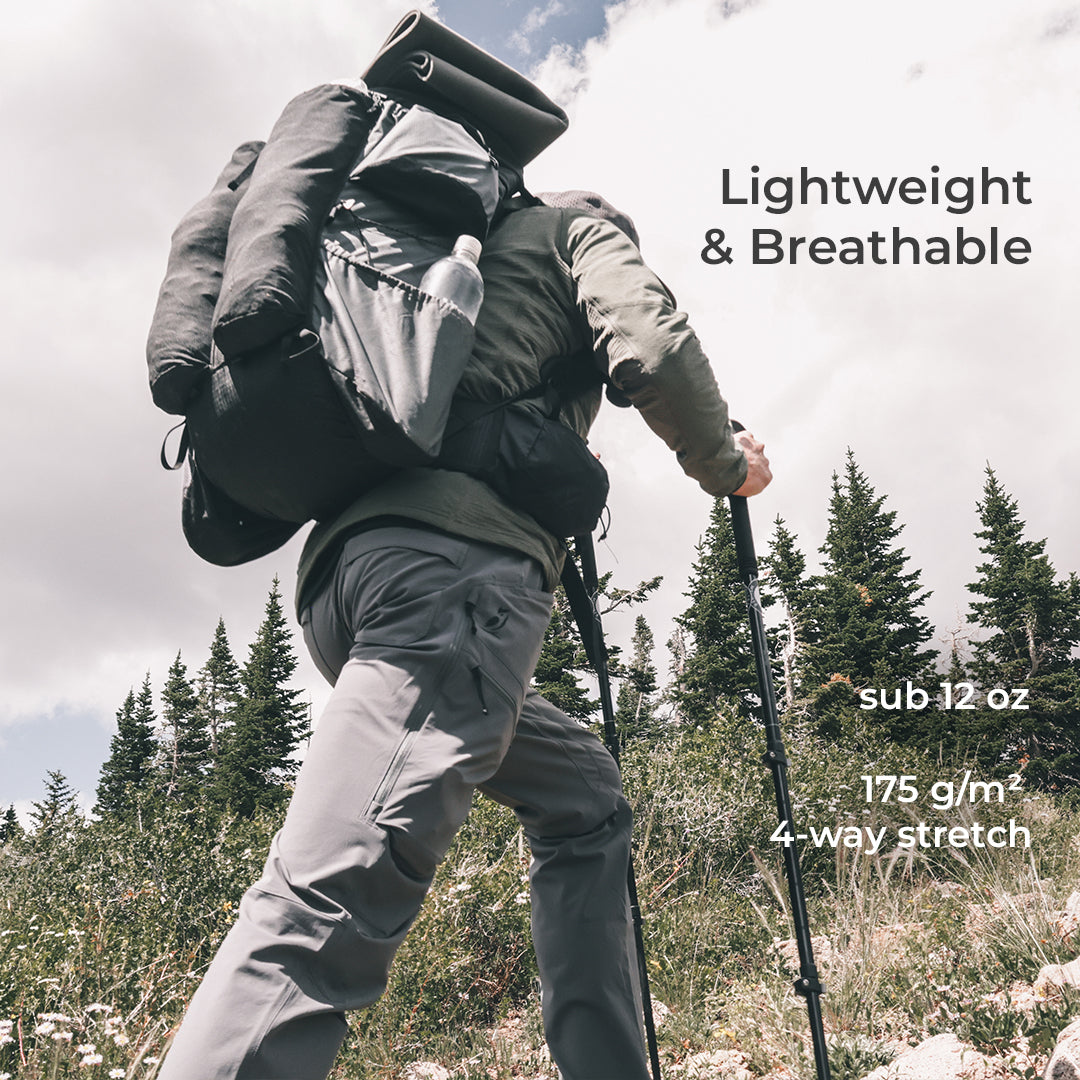 rear view of hiker wearing gray vented pants hiking up mountain slope