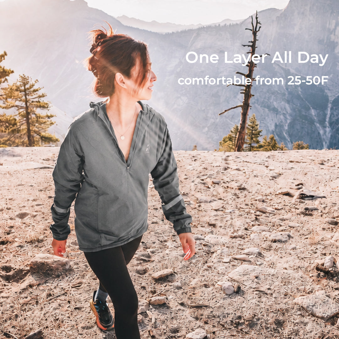 women walks across high elevation landscape wearing gray active mid layer