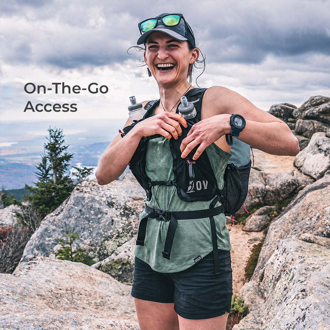 Hiker paused to get something out of running vest style pack harness. Text on screen says, "On-The-Go Access."