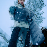 front view of man pulling sleeping bag out near his tent