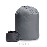 Two gray storage bags for a backpacking quilt: a large drawstring long-term storage sack and a smaller compressible stuff sack.