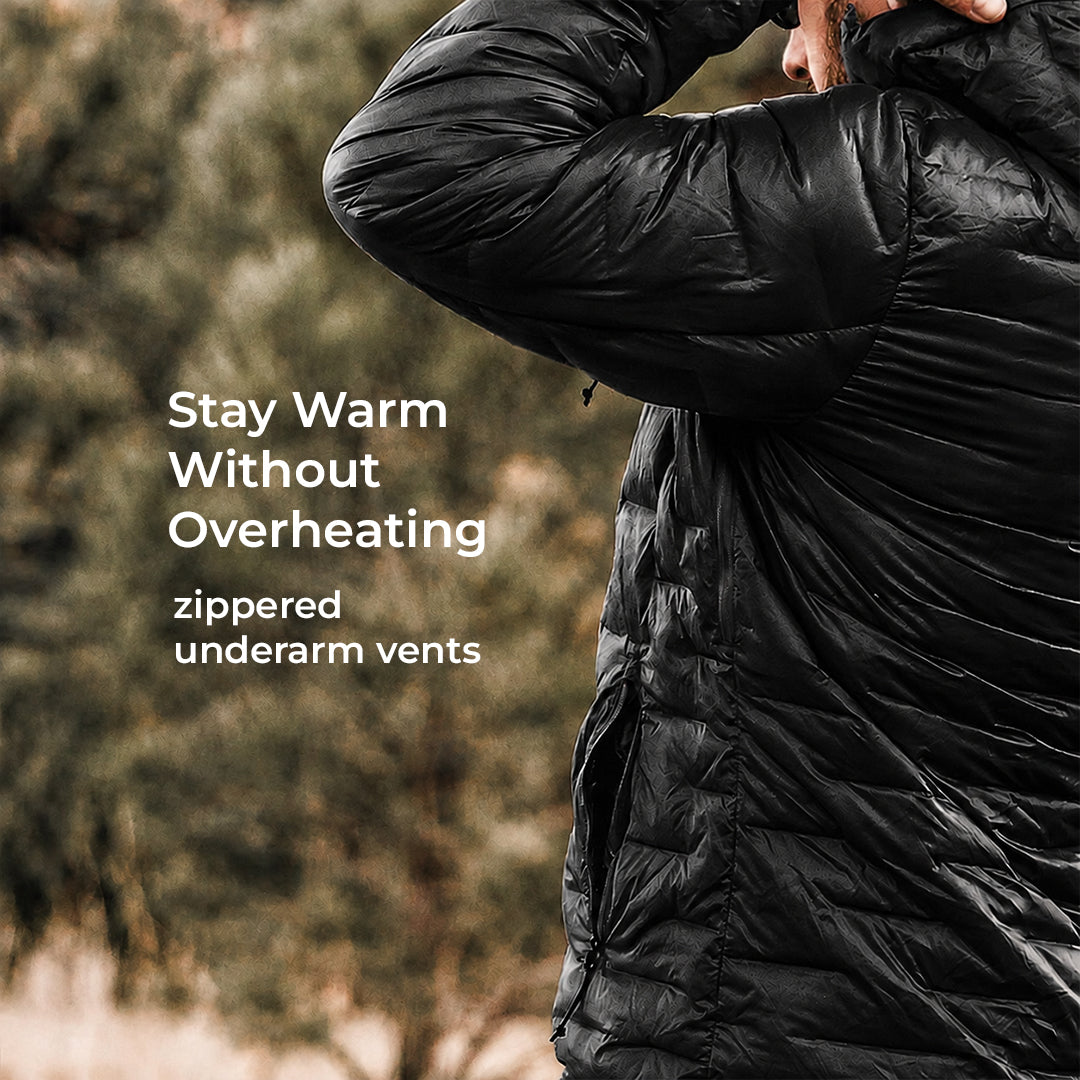 A close-up of a person wearing a black quilted puffer jacket outdoors, with overlaid text reading 'Stay Warm Without Overheating' and 'zippered underarm vents.'.