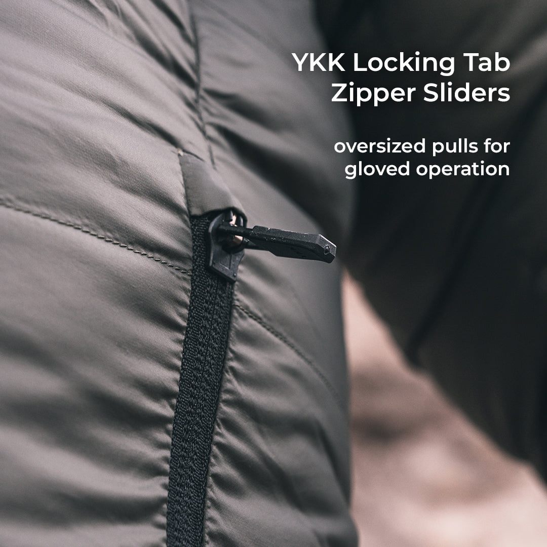 Close-up of a dark gray puffer jacket zipper with a black YKK locking tab slider, featuring white text overlay that reads 'YKK Locking Tab Zipper Sliders' and 'oversized pulls for gloved operation'.