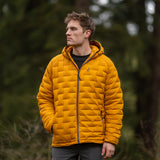 Man wearing insulated hooded down jacket shown from the front in outdoor setting.