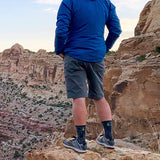 side view of man wearing backpacking shorts while observing view of canyon