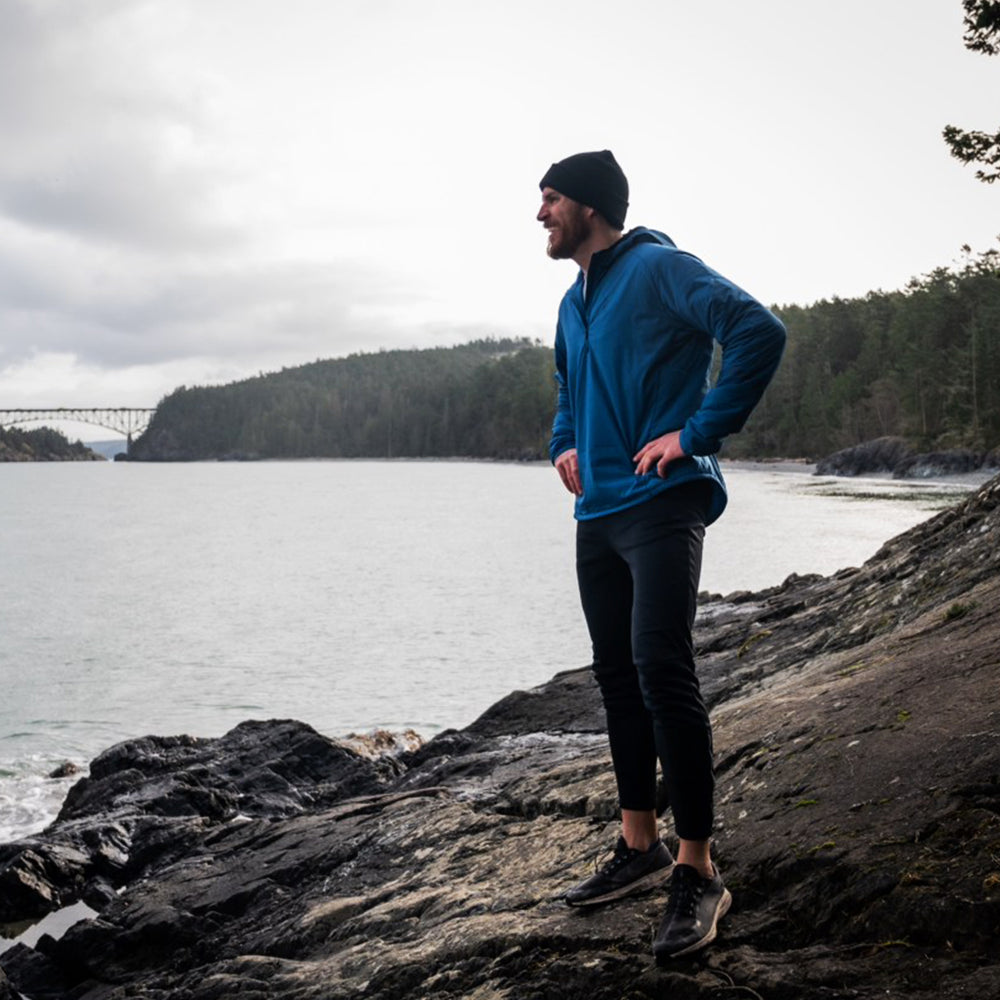 male runner wearing Ventus mid layer pausing by river to catch his breath