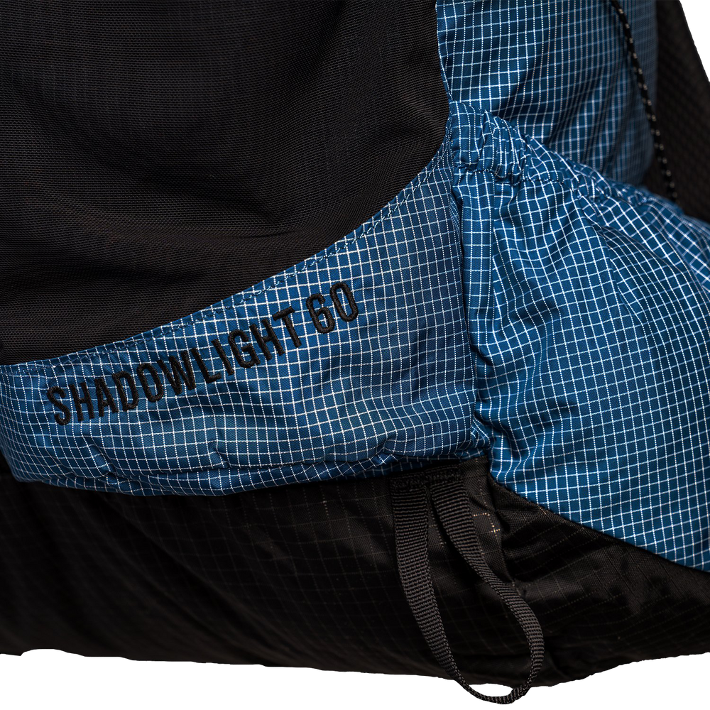 The Shadowlight Ultralight Backpack featuring a blue and black color scheme & 60L capacity