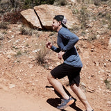 male wearing blue sun hoodie while trail running in the desert