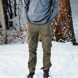 front view of man wearing green hiking pants in the snow