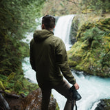 side view of olive men's hiking hoodie by waterfall