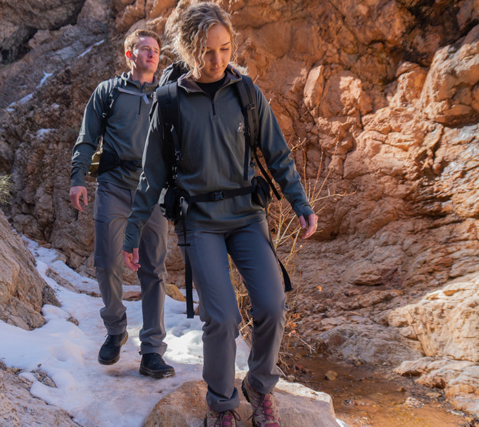 man & woman hiking with gray outdoor pants