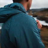 close view from side of water beading up & rolling of water resistant active mid layer