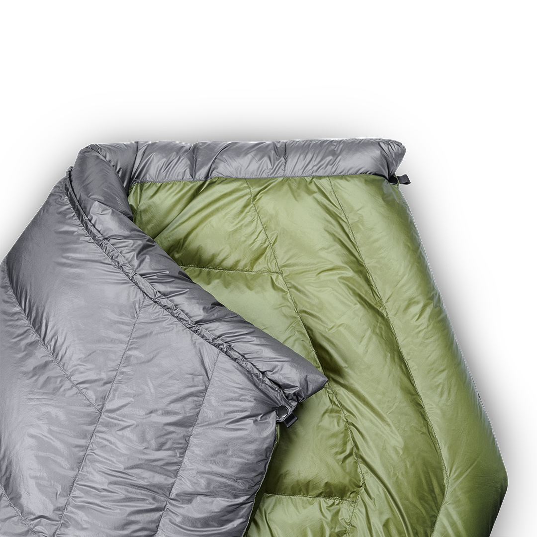 Close-up of a gray and green backpacking quilt showing the unique taper that causes the quilt to wrap naturally around your shoulders.