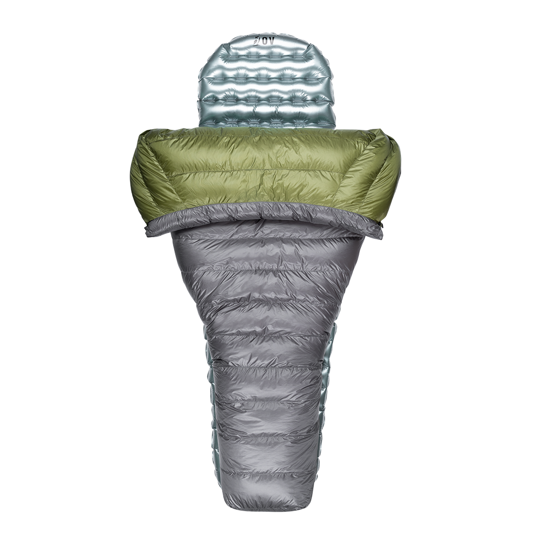 Top-down view of a gray and green backpacking quilt partially open, shown with a silvery inflatable sleeping pad inside.