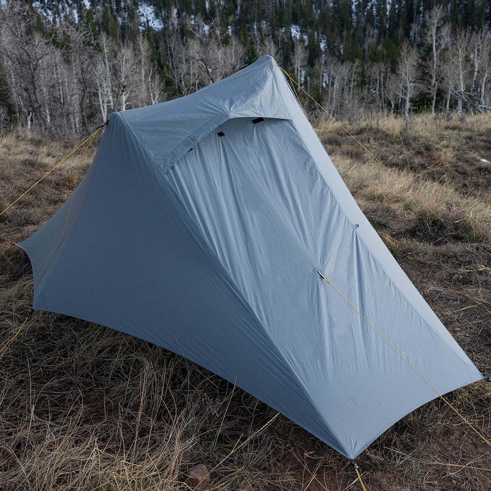 Side view of ultralight trekking pole backpacking tent pitched in alpine terrain