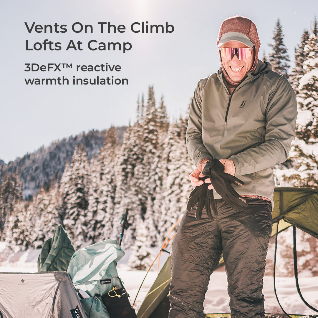 A man in winter outdoor gear stands in a snowy mountain campsite setting, holding black gloves. Text on the left reads 'Vents On The Climb Lofts At Camp' and '3DeFX™ reactive warmth insulation.