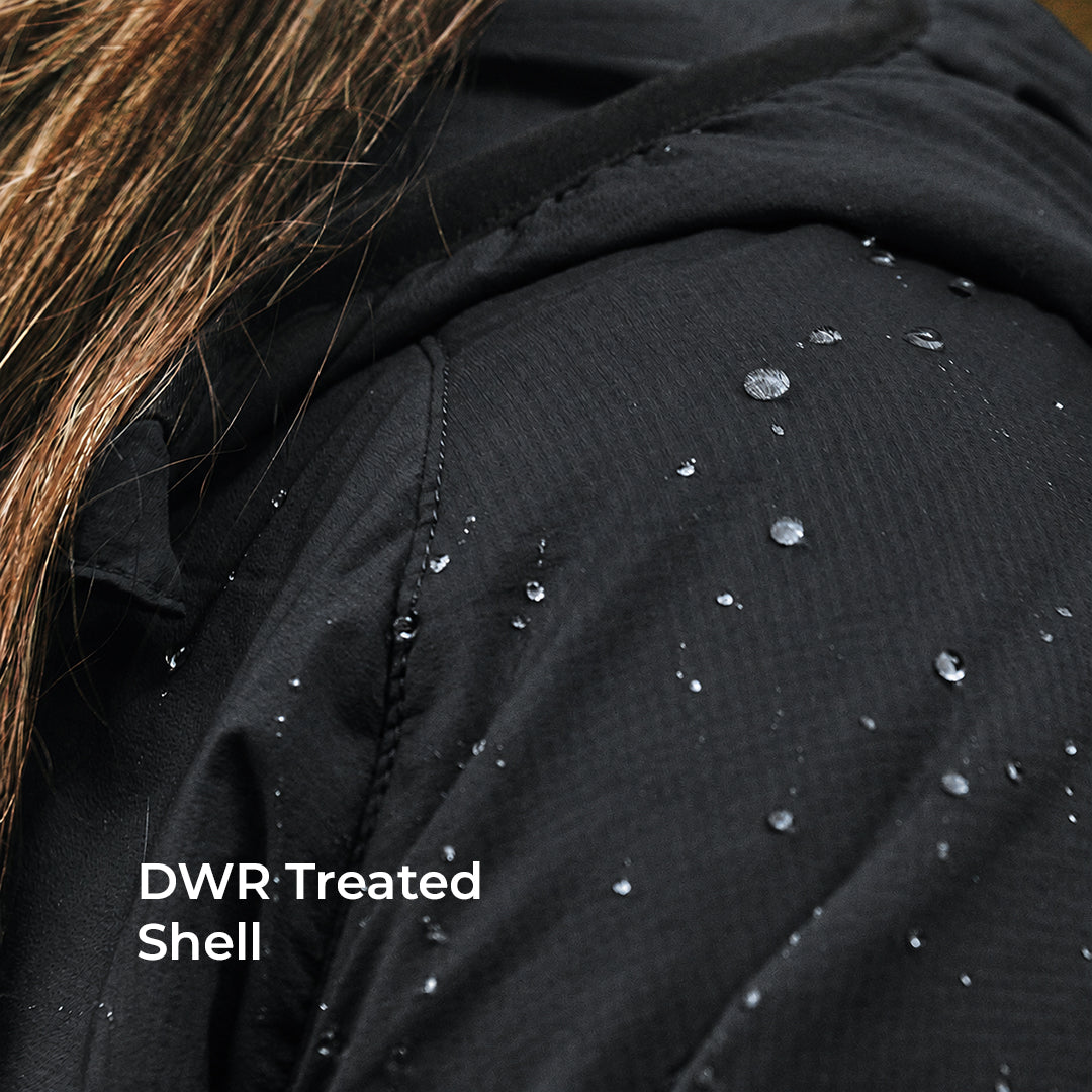 Close-up of a black hooded jacket with water droplets on the treated fabric, showing its waterproof DWR shell finish. White text in the lower left reads 'DWR Treated Shell'.