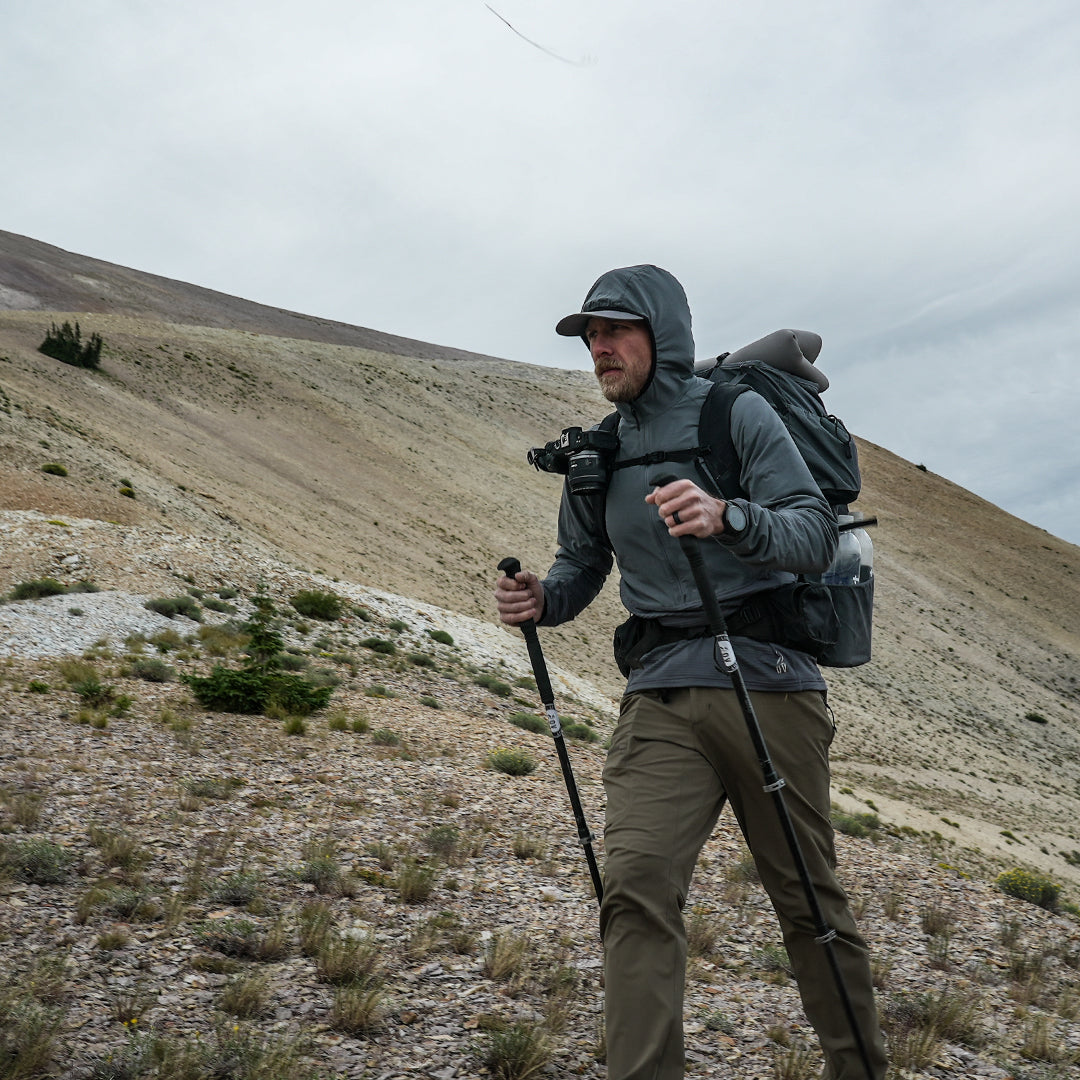 side view of man hiking up steep and exposed mountain slopes