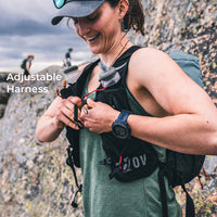 close view of hiker adjusting running vest style harness beside large rocky terrain. Text callouts say, "Adjustable Harness."