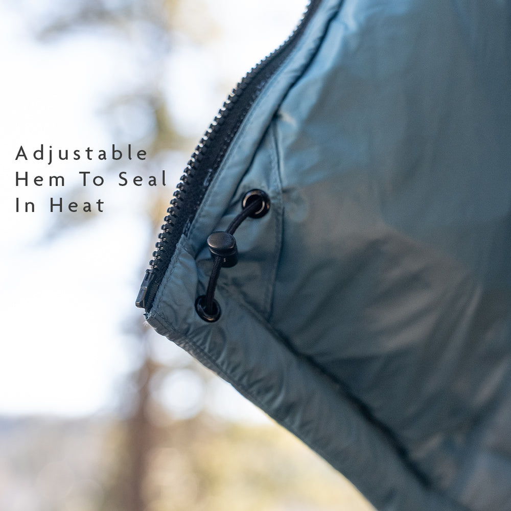 Close-up of insulated jacket hem with adjustable drawcord and cord lock, designed to seal in warmth and block cold air.