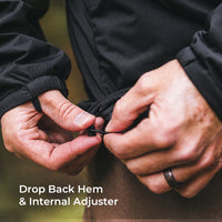 Close-up of a person's hands adjusting the hem of a black outdoor jacket, with text overlay reading 'Drop Back Hem & Internal Adjuster'.