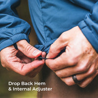 Close-up of a person's hands adjusting the hem of a blue jacket, demonstrating how to use the internal adjuster and drop back hem feature. White text at the bottom reads 'Drop Back Hem & Internal Adjuster'.