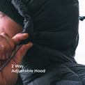 close view of a woman adjusting the hood on her black puffy down jacket
