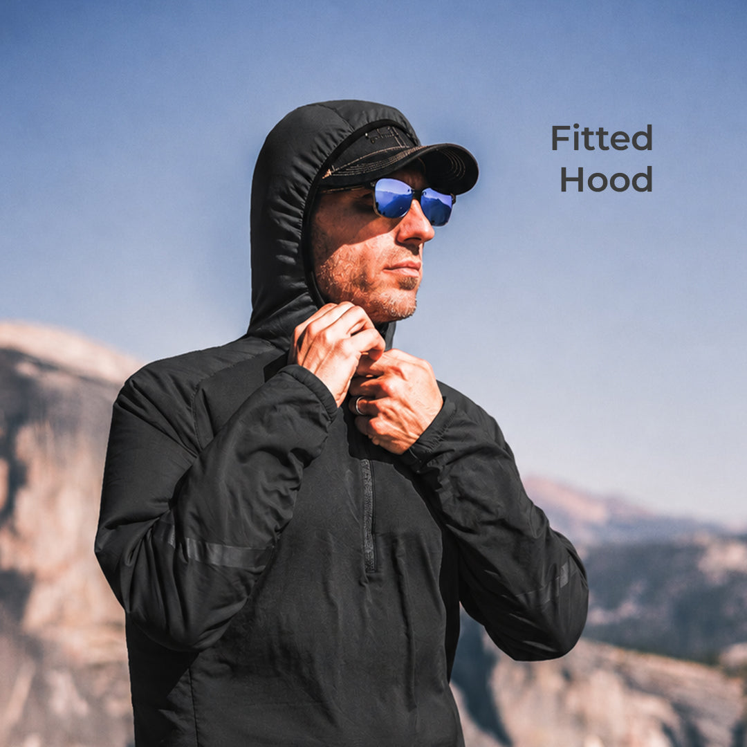 close view of man wearing dark hooded mid layer jacket on mountain peak