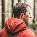A man in a forest wearing a fitted hooded jacket, shown from the back and side. The text 'Fitted Hood' appears on the left.