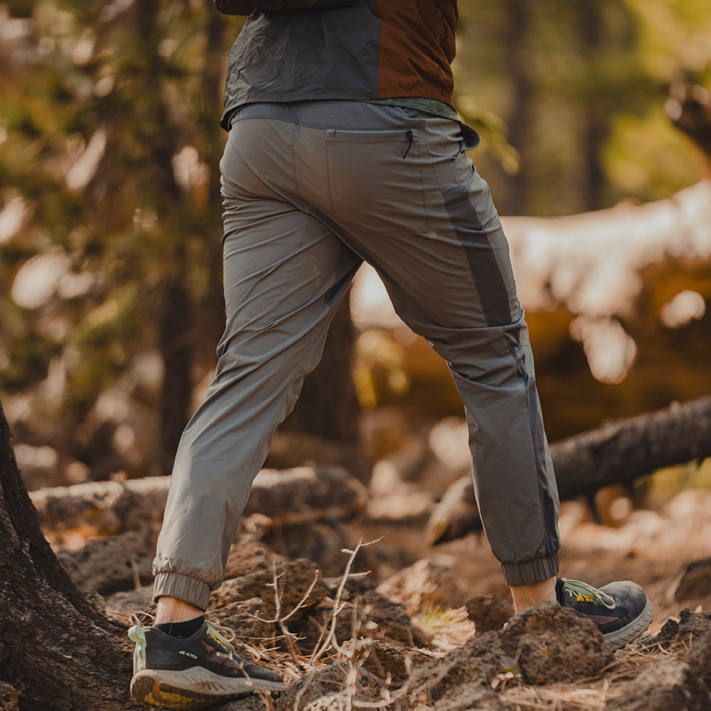 side view of man wearing men's gray Skyline Joggers in the woods