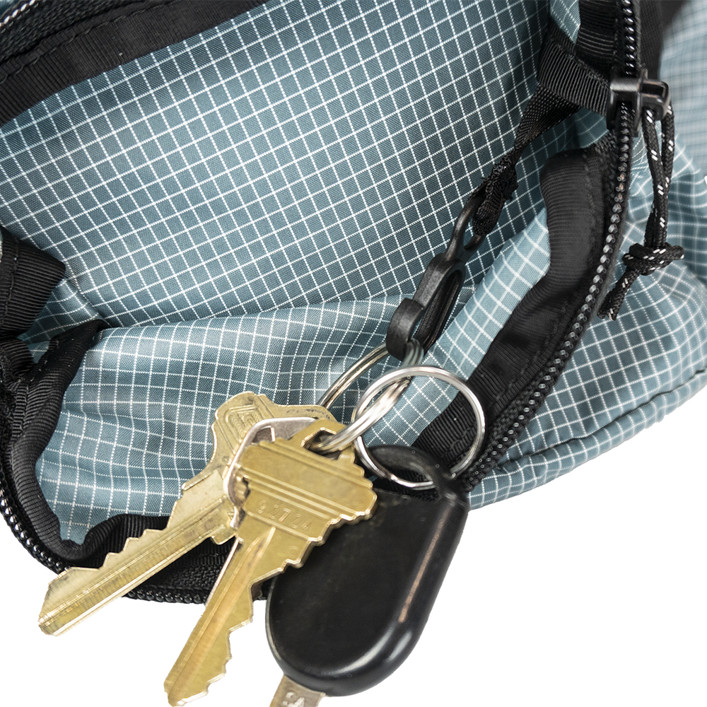 Close-up of the Shadowlight Ultralight Backpack's hip belt pocket with attached key clip