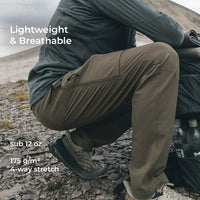 man crouching and wearing lightweight hiking pants with side zipper vents, articulated knees, and volumized pockets.