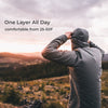 A person wearing a dark gray hooded lightweight jacket stands outdoors in a mountain landscape at sunset, with text on the left reading 'One Layer All Day' and 'comfortable from 25-50F'.