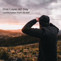 A person wearing a black hooded jacket stands outdoors on a mountain landscape at sunset, with text in the upper left reading 'One Layer All Day' and 'comfortable from 25-50F'.