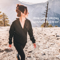 A woman hiking in a black quarter-zip fleece jacket and black leggings on a rocky mountain trail, with text overlay reading 'One Layer All Day' and 'comfortable from 25-50F'.