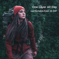 A woman hiking outdoors wearing a rust red one-layer jacket, a red knit beanie, and carrying a large dark green backpack. White text on the right reads 'One Layer All Day' and 'comfortable from 25-50F'.