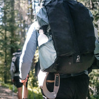 rear view of Shadowlight backpack on hiker walking through wooded area.