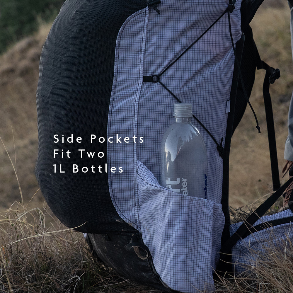 Backpack side pockets holding two 1-liter water bottles for easy access while hiking.