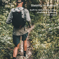 rear view of fastpacker running down narrow trail in a wooded area. Text callout says, "Stability In Motion - built to reduce bouncing, chafing, & rubbing on the move."